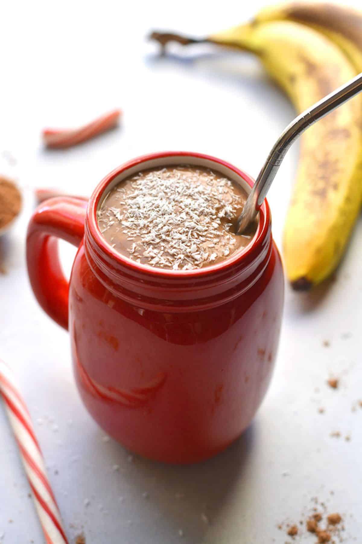 A hot chocolate smoothie with a straw in the cup.