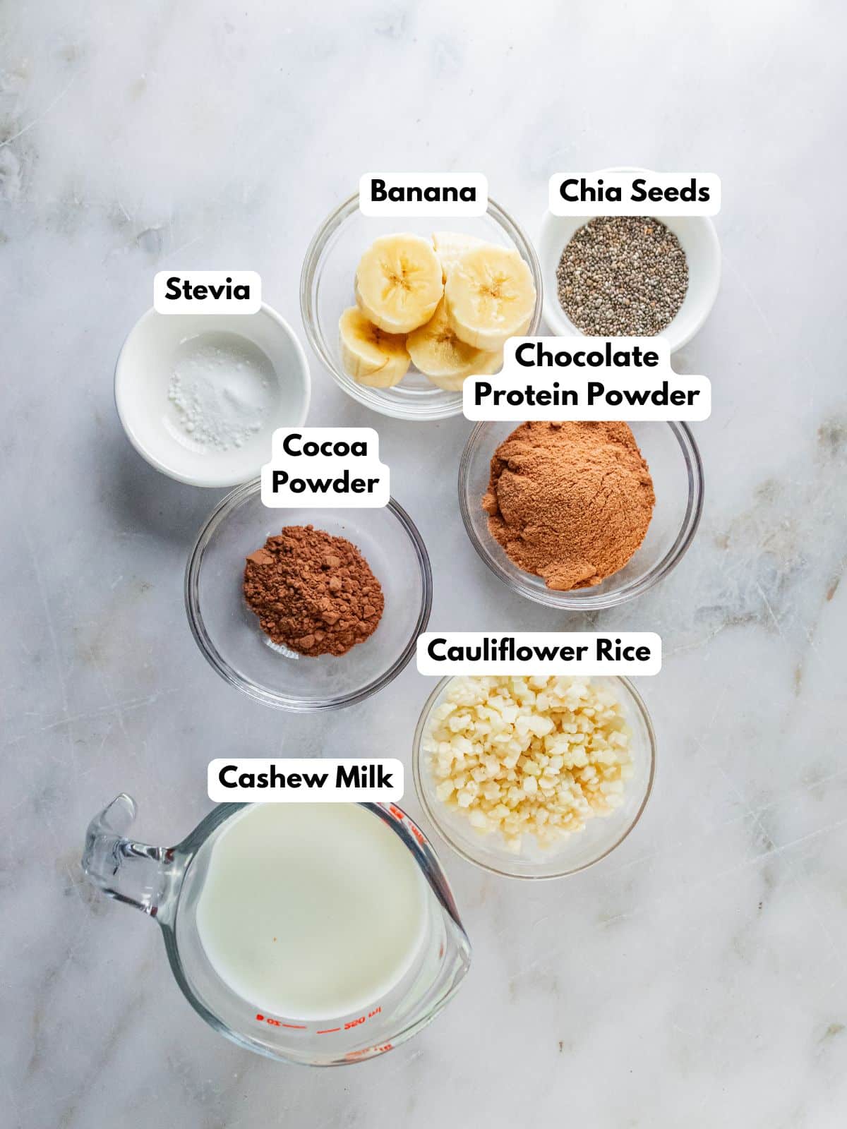 Ingredients to make a hot chocolate smoothie in bowls on a table.