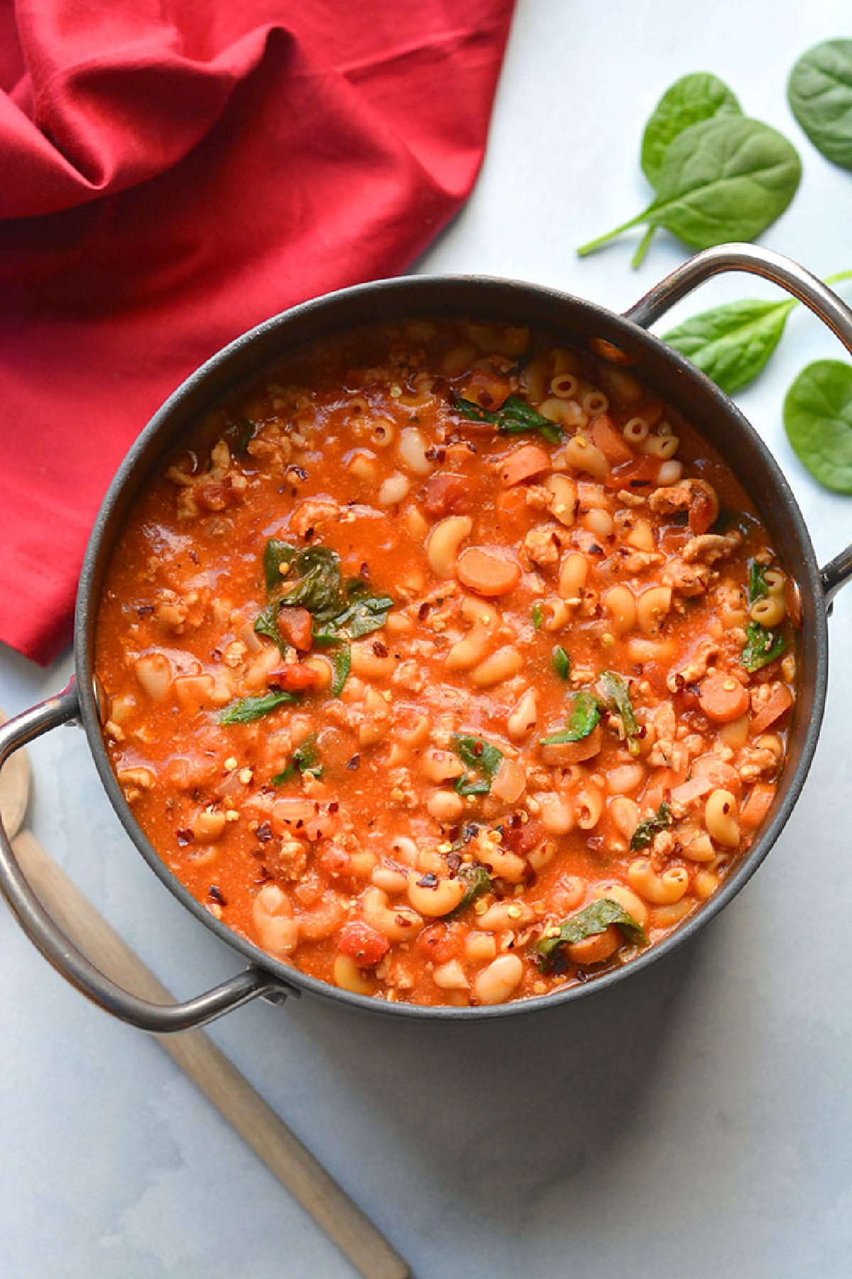 Pasta fagioli in a large pot on a white table.