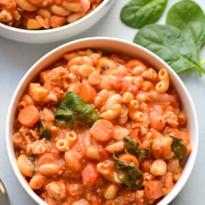 Pasta fagioli in a white bowl on a table.