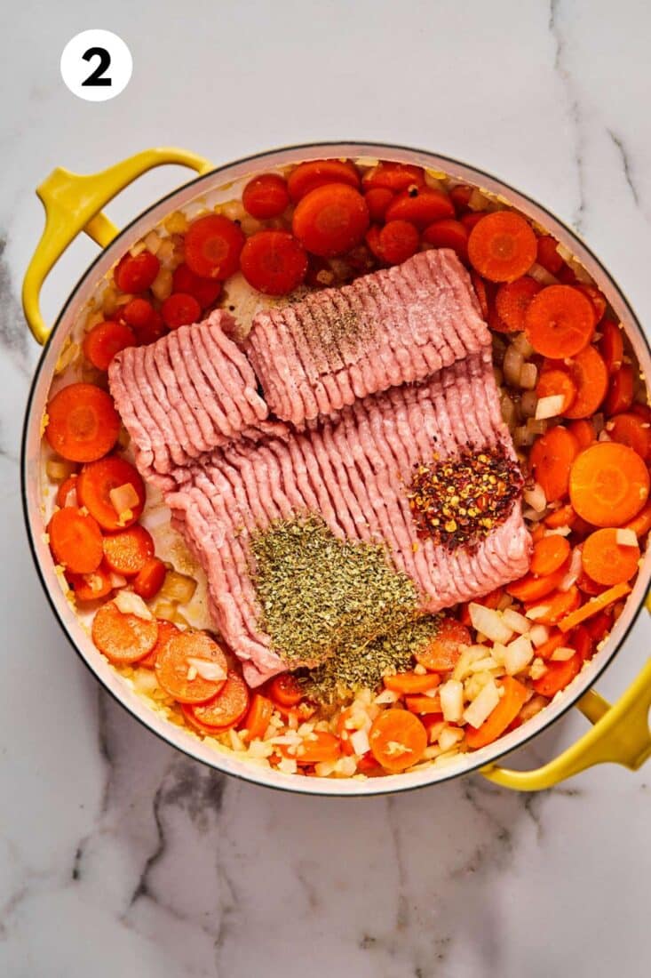 Ground turkey and seasonings are added to the pot with the cooked vegetables.