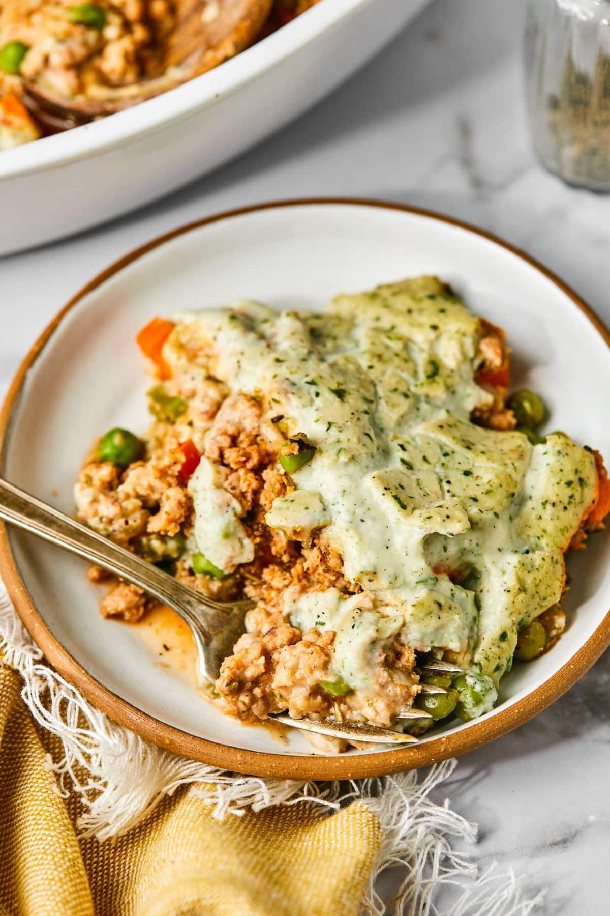Healthy shephards pie on a plate with a fork resting in the front.