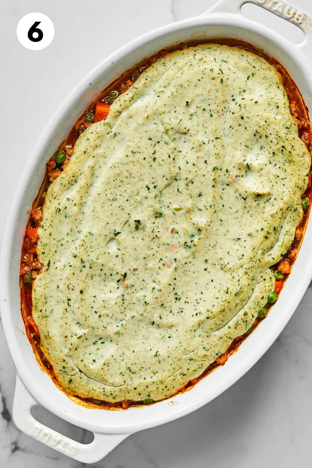 Baked shepherds pie in an oval casserole dish.