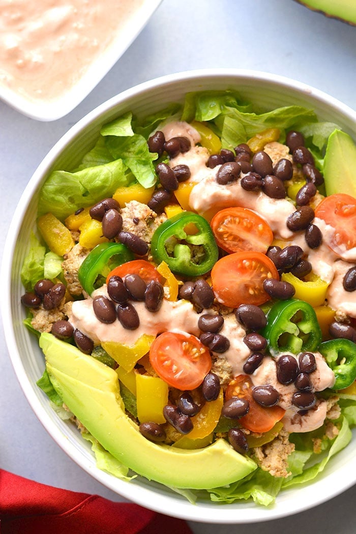 This Healthy Taco Salad is a low calorie meal packed with veggies, ground turkey, black beans and topped with a Greek yogurt salsa dressing. A super simple meal that's filling, high in protein and fiber to keep cravings away. 