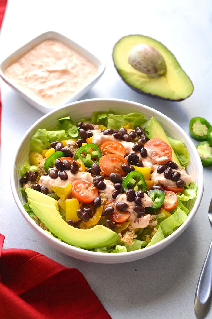 This Healthy Taco Salad is a low calorie meal packed with veggies, ground turkey, black beans and topped with a Greek yogurt salsa dressing. A super simple meal that's filling, high in protein and fiber to keep cravings away. 