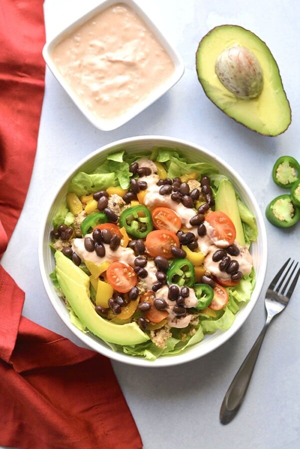 This Healthy Taco Salad is a low calorie meal packed with veggies, ground turkey, black beans and topped with a Greek yogurt salsa dressing. A super simple meal that's filling, high in protein and fiber to keep cravings away.