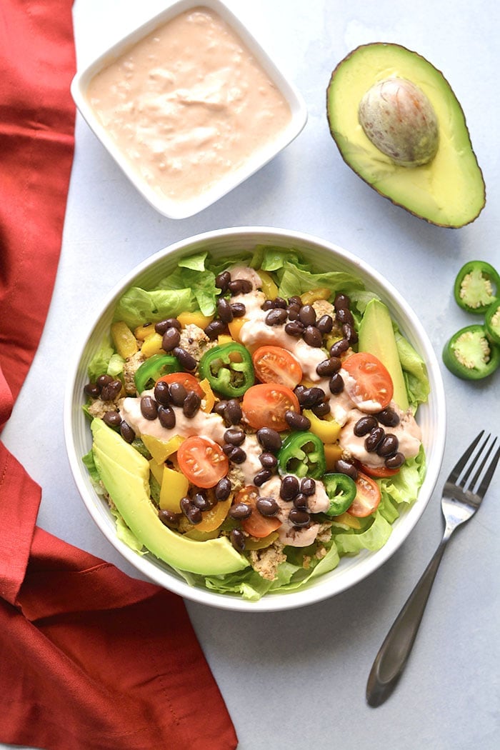 This Healthy Taco Salad is a low calorie meal packed with veggies, ground turkey, black beans and topped with a Greek yogurt salsa dressing. A super simple meal that's filling, high in protein and fiber to keep cravings away. 