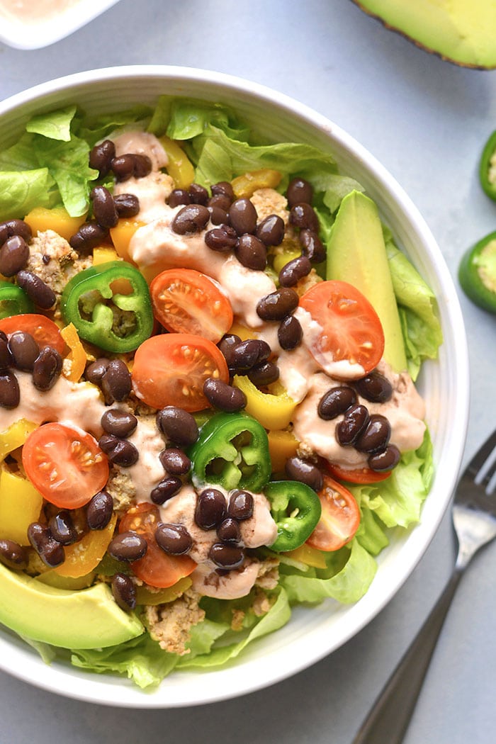 This Healthy Taco Salad is a low calorie meal packed with veggies, ground turkey, black beans and topped with a Greek yogurt salsa dressing. A super simple meal that's filling, high in protein and fiber to keep cravings away. 