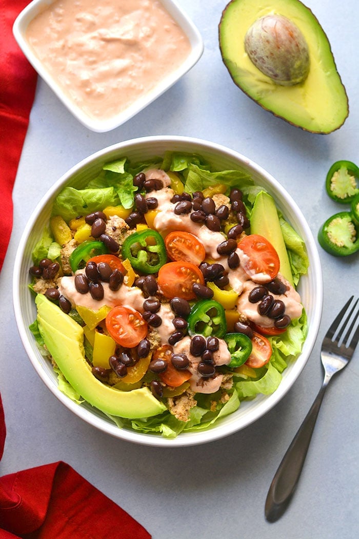 This Healthy Taco Salad is a low calorie meal packed with veggies, ground turkey, black beans and topped with a Greek yogurt salsa dressing. A super simple meal that's filling, high in protein and fiber to keep cravings away. 