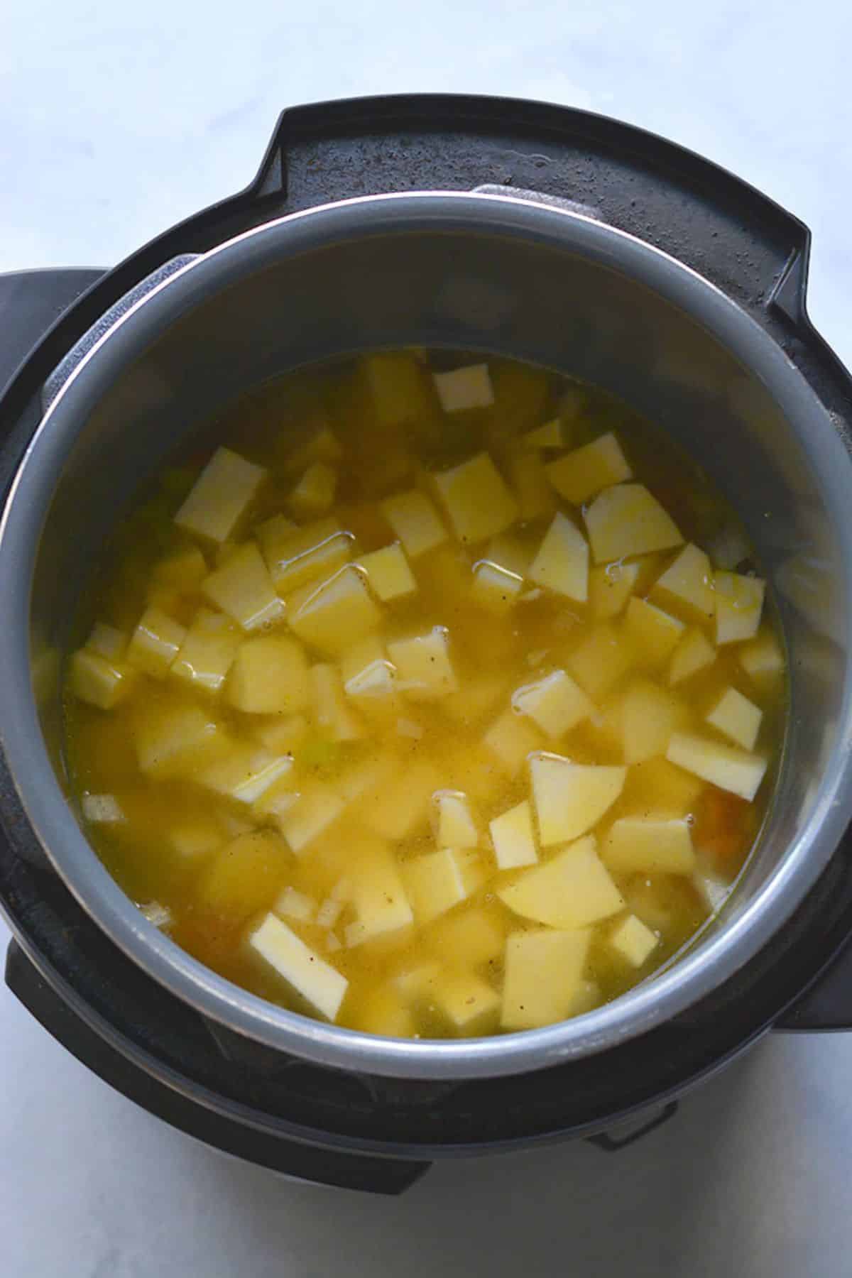 Sweet potatoes and broth added to the pot.
