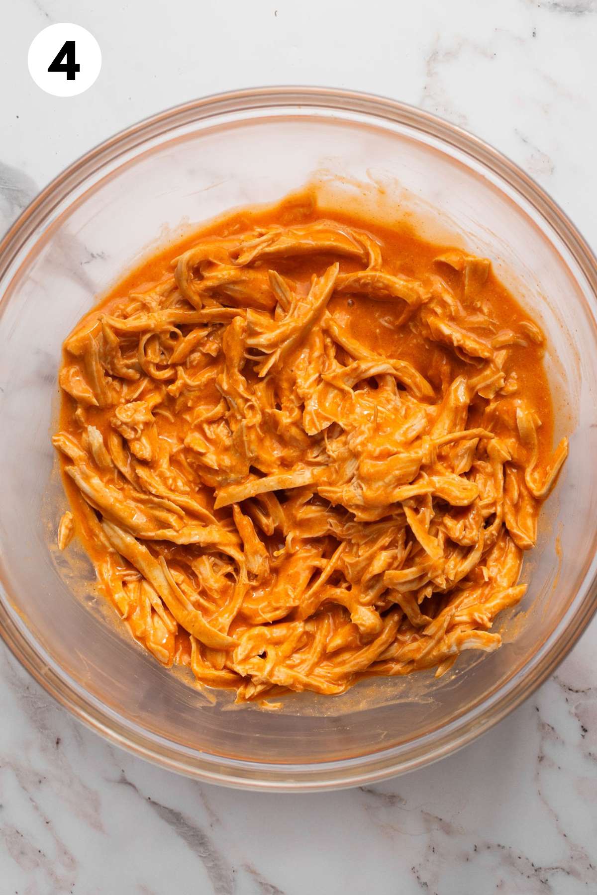 Buffalo sauce mixed with the shredded chicken.