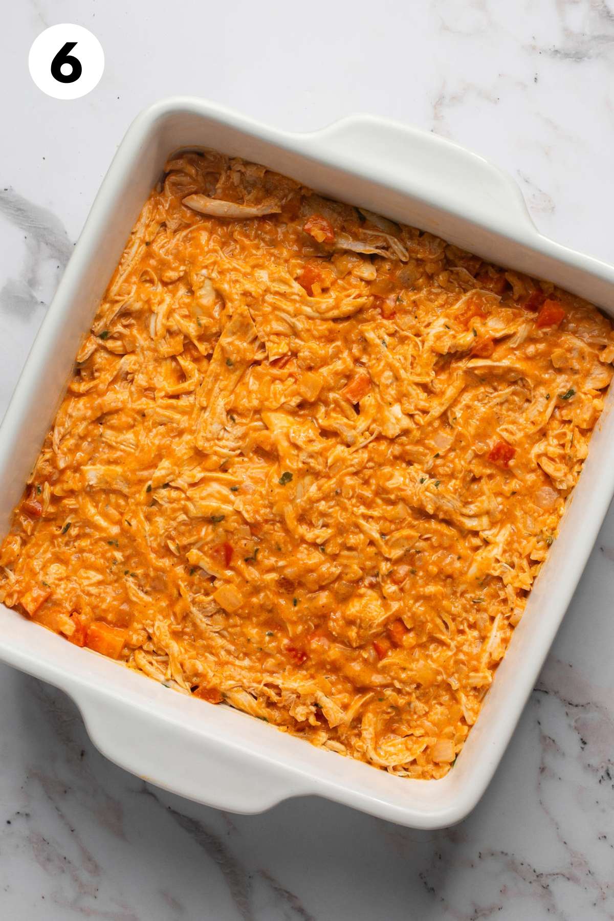 Buffalo chicken mixture in a square baking dish.