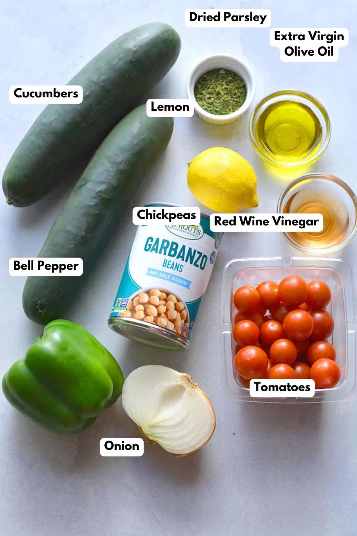Ingredients to make a healthy chickpea salad with text labels to the side to identify each.