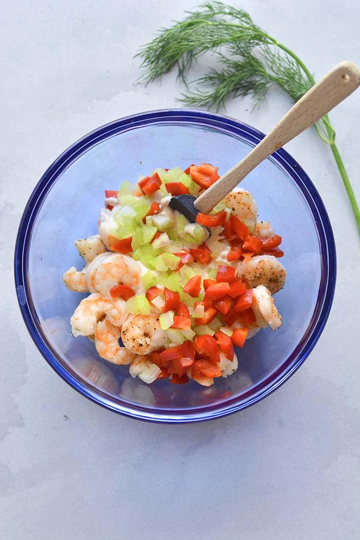 mixing bowl with ingredients for making a shrimp salad with Greek yogurt