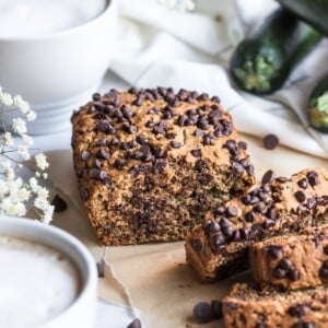 Slices of low calorie zucchini bread on board in front of the loaf.