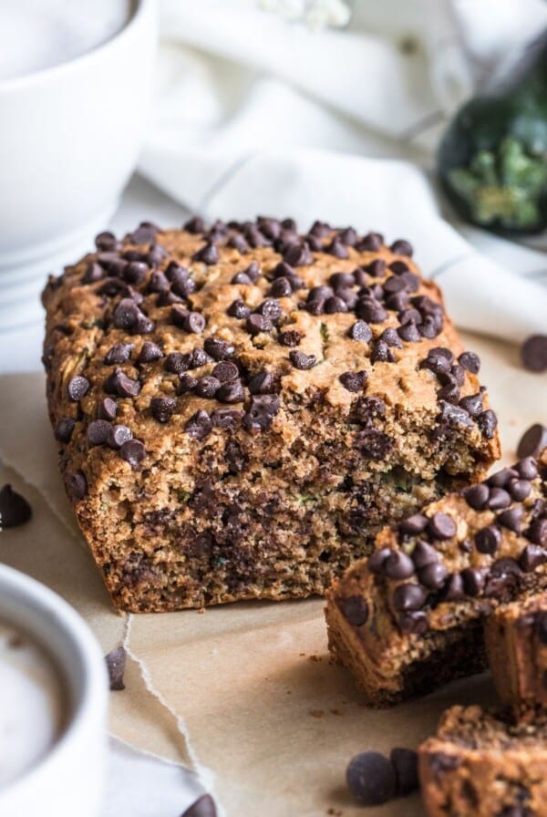 Slices of low calorie zucchini bread on board in front of the loaf.