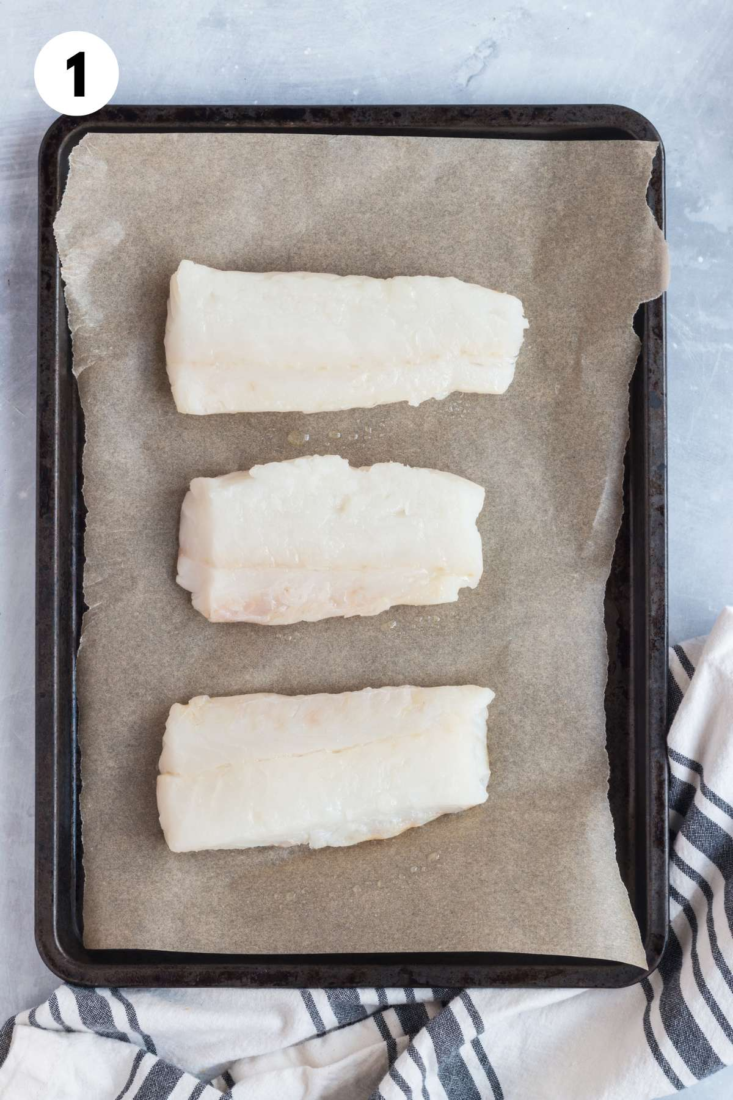 Raw fish fillets on a baking pan before baking.