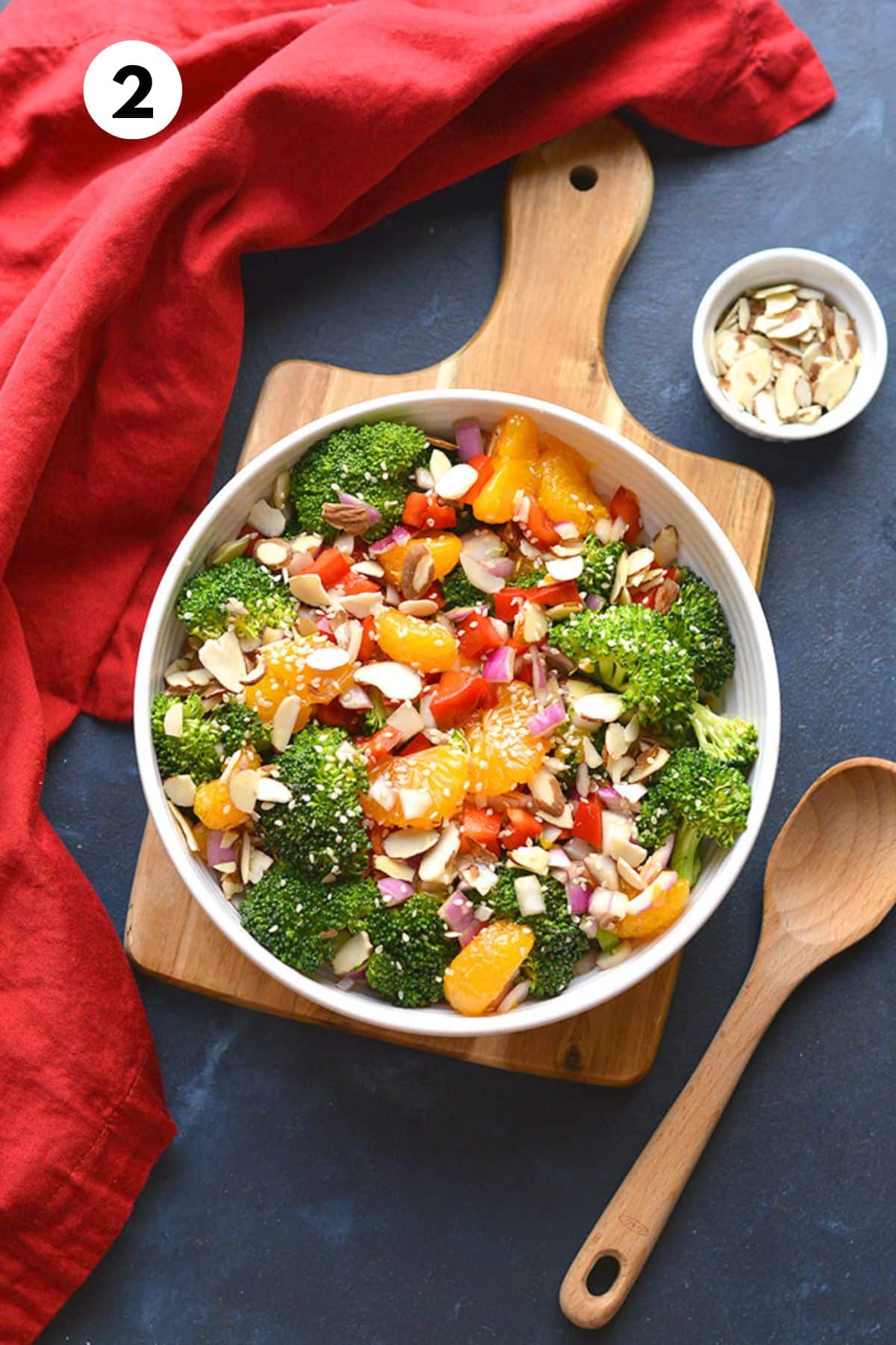 Asian broccoli salad mixed together with a small bowl of almonds to the side.