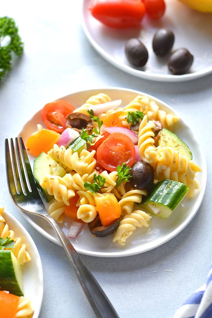 This Low Calorie Pasta Salad is loaded with vegetables and chickpea pasta. Made light with healthy ingredients this tasty, gluten free and dairy free pasta salad recipe is one you will make time and again. Perfect for summer eating as a side dish or appetizer!