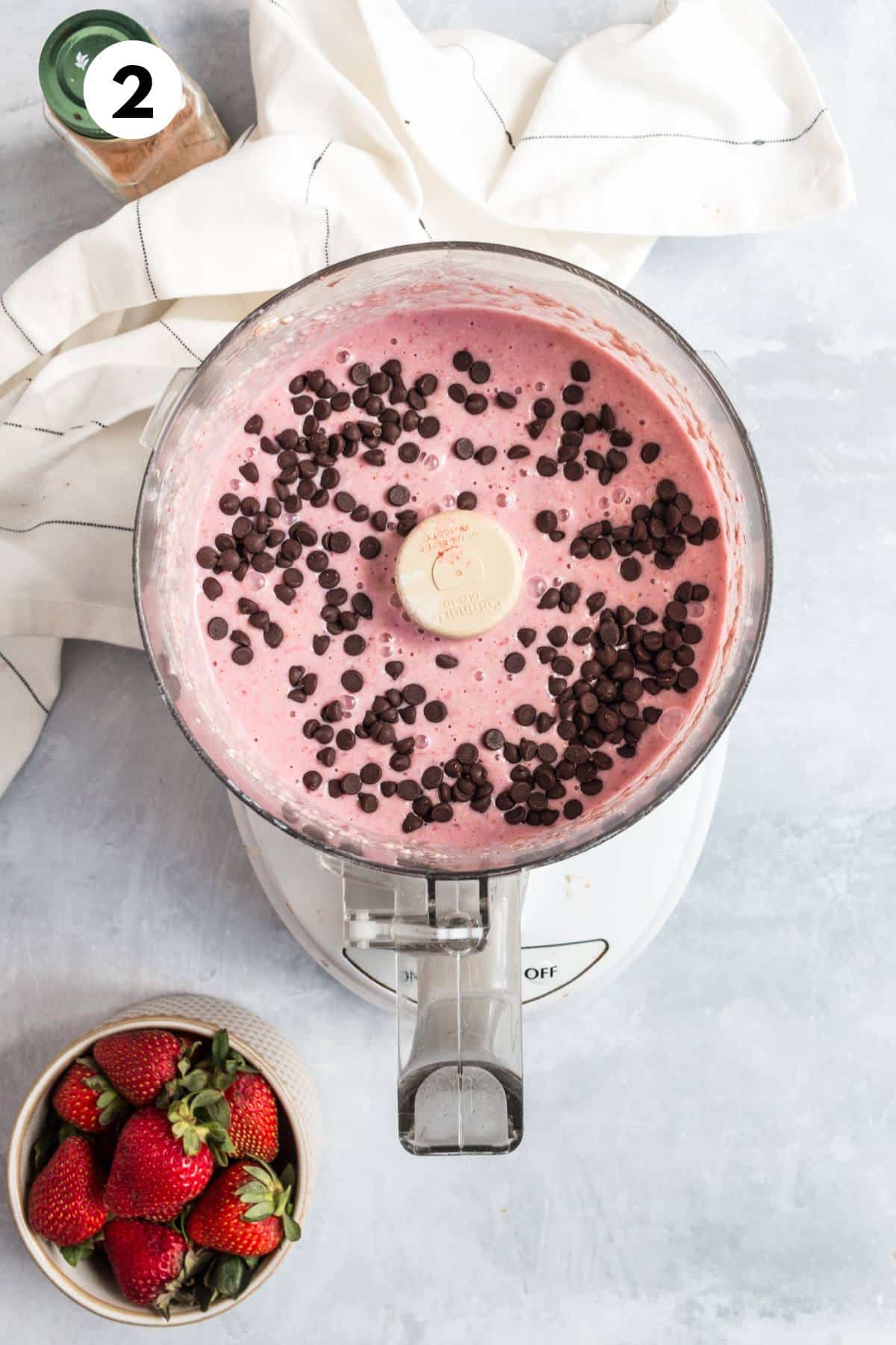 Chocolate chips added to strawberry pancake batter in a food processor.