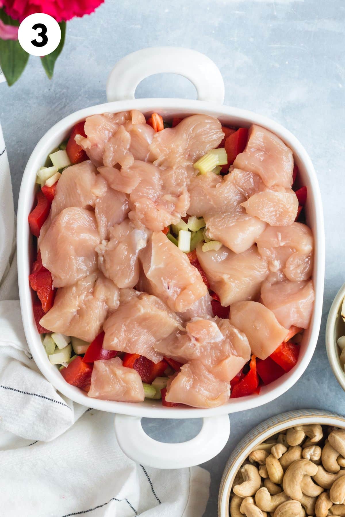 Raw chicken added on top of the veggies.