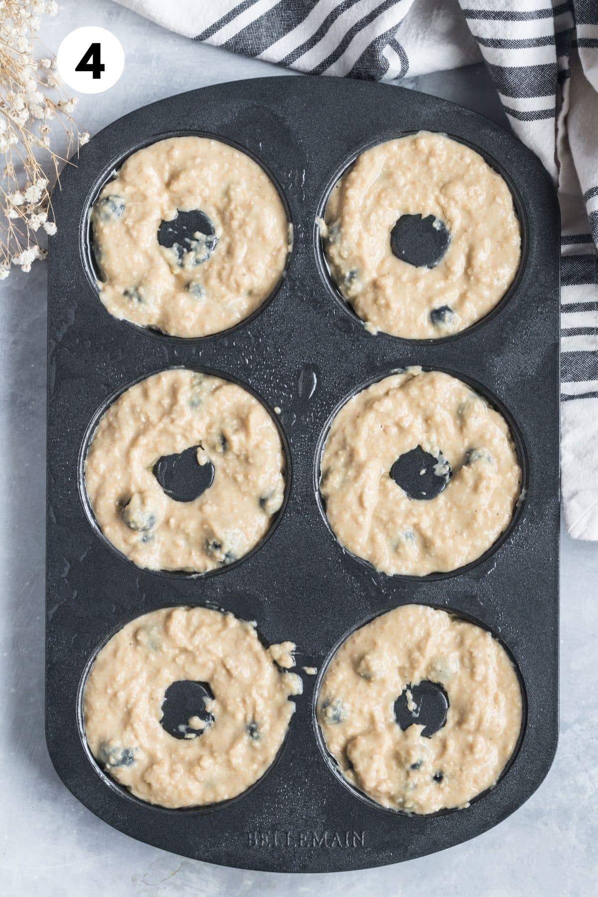 Donut batter added to a donut pan.