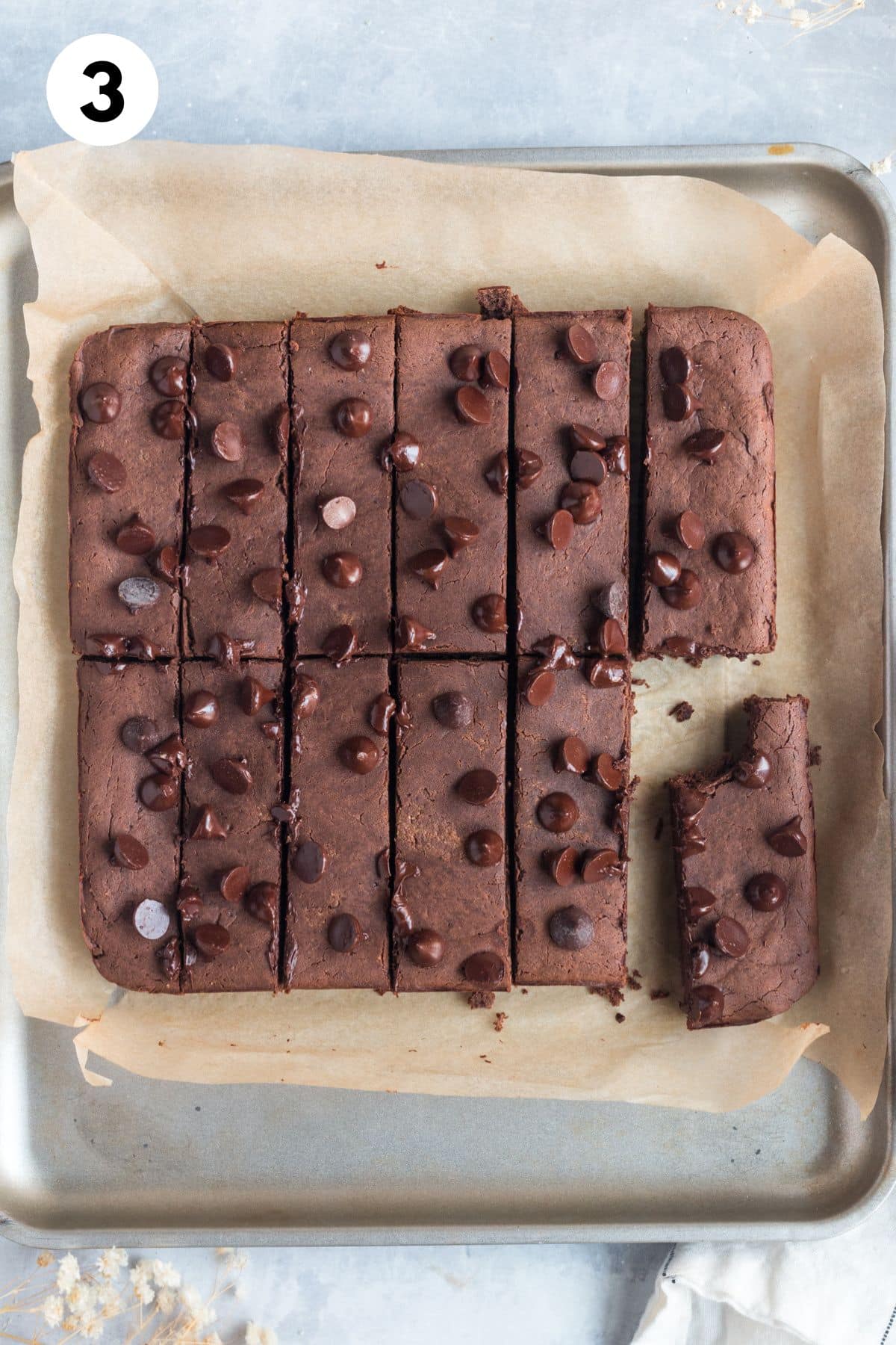 Chocolate protein bars cut on a baking sheet.