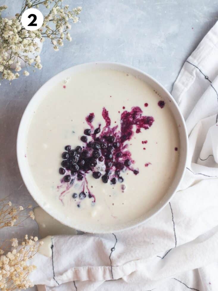 Liquid ingredients and blueberries added to the bowl.