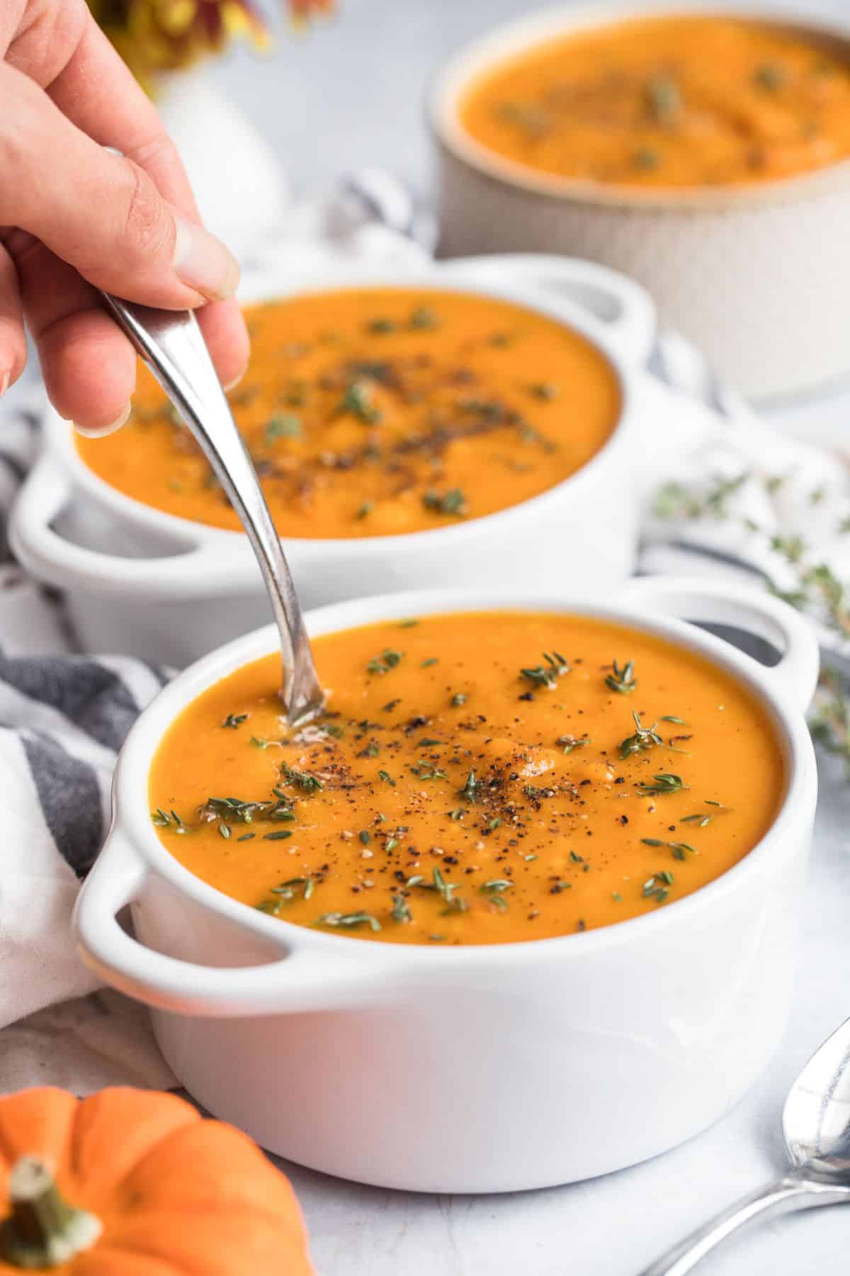Two bowls of butternut squash and sweet potato soup.