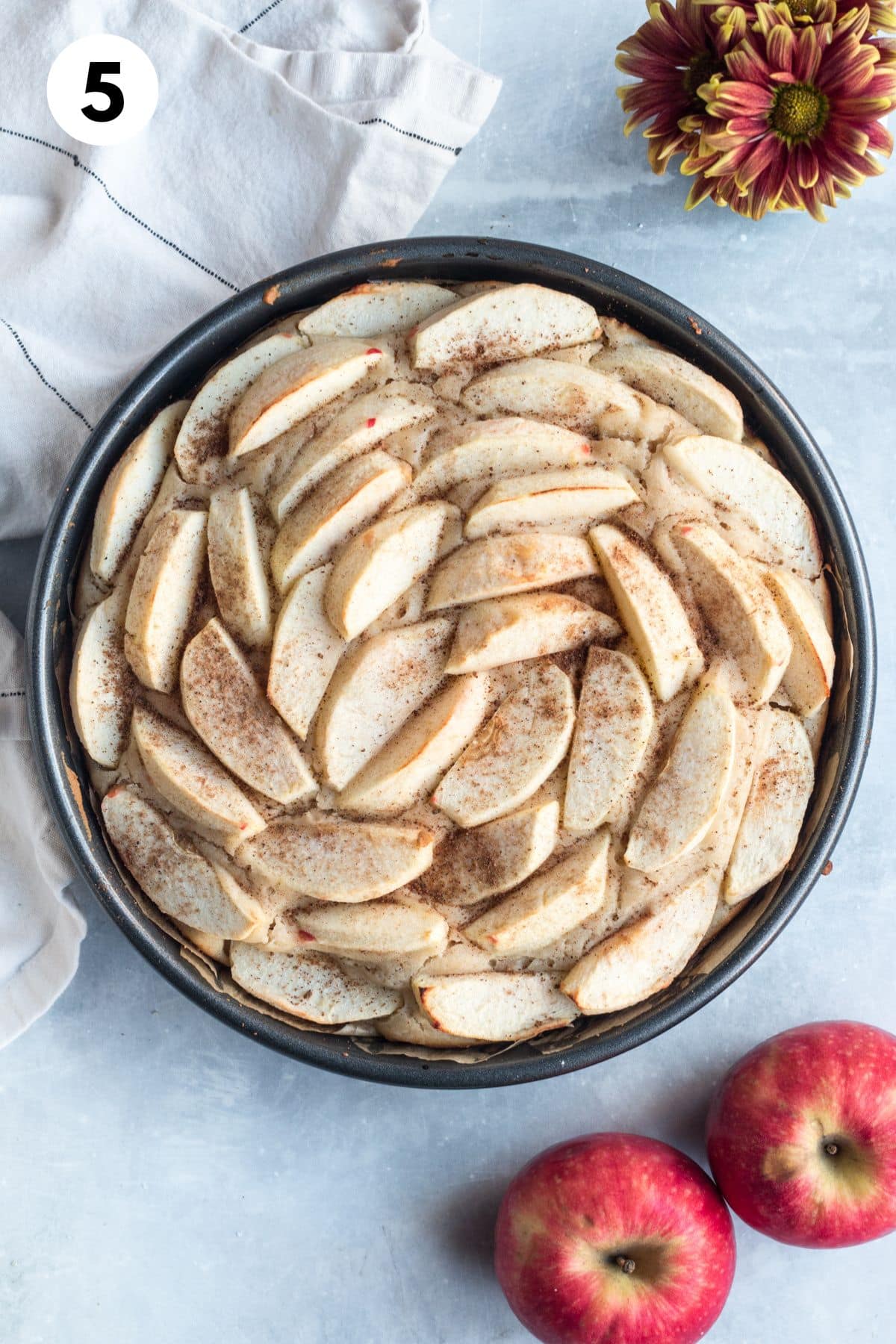 Apple slices layered in a round baking pan.