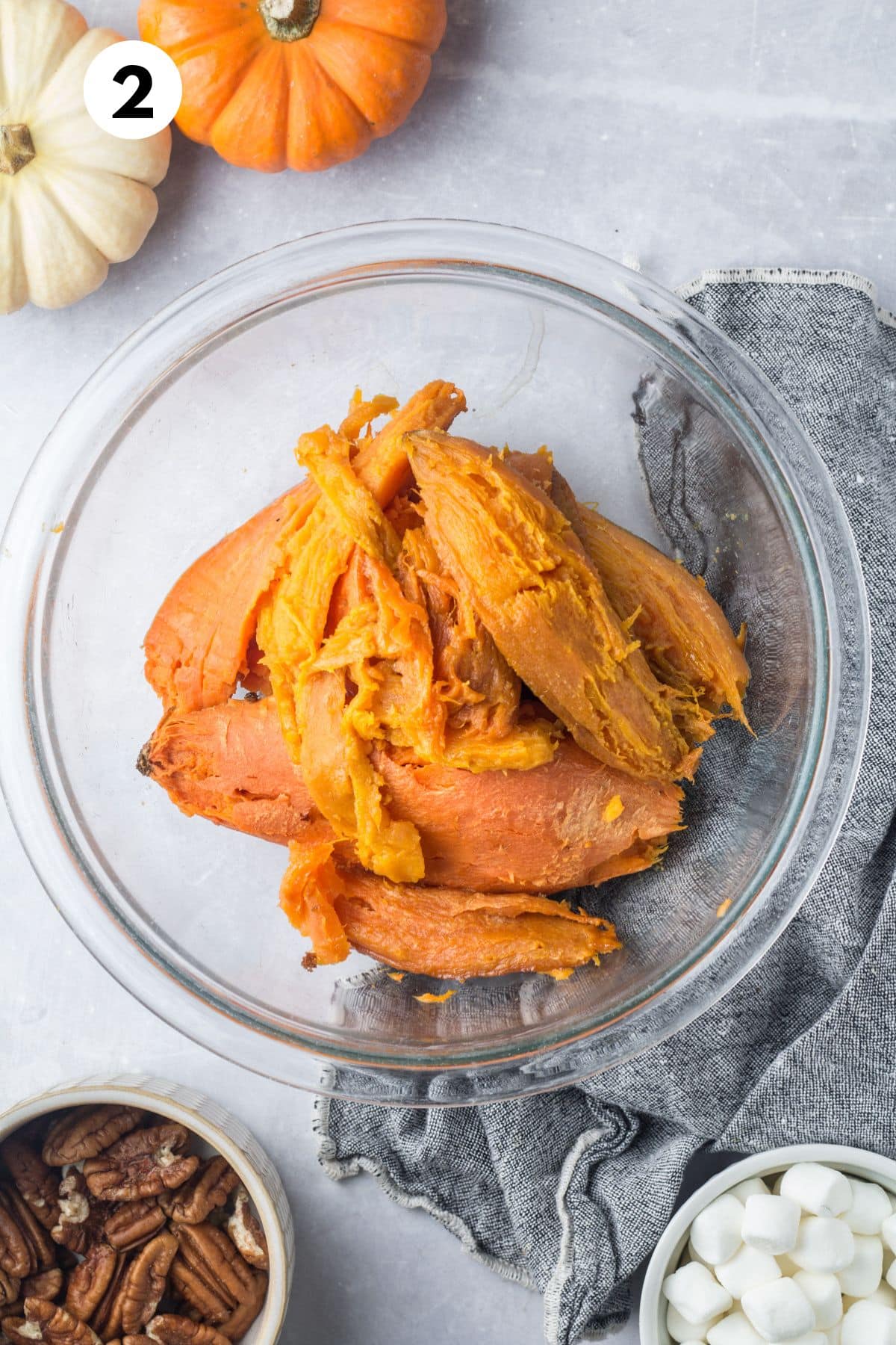 Peeled sweet potatoes in a glass bowl.