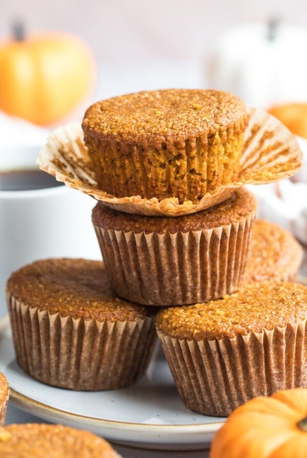 A stack of pumpkin cornbread muffins on a plate.