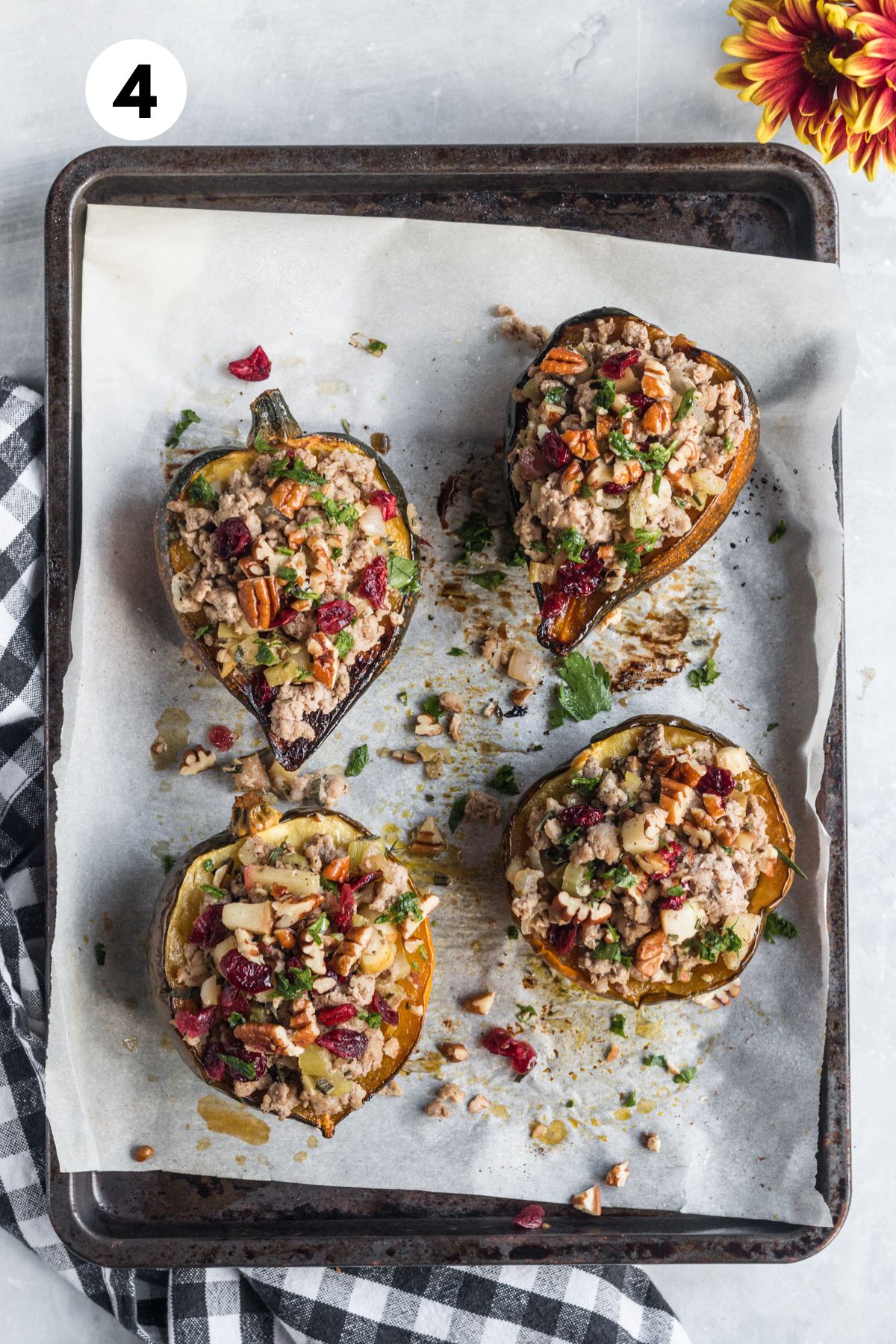 Stuffing added to each acorn squash on the baking sheet.