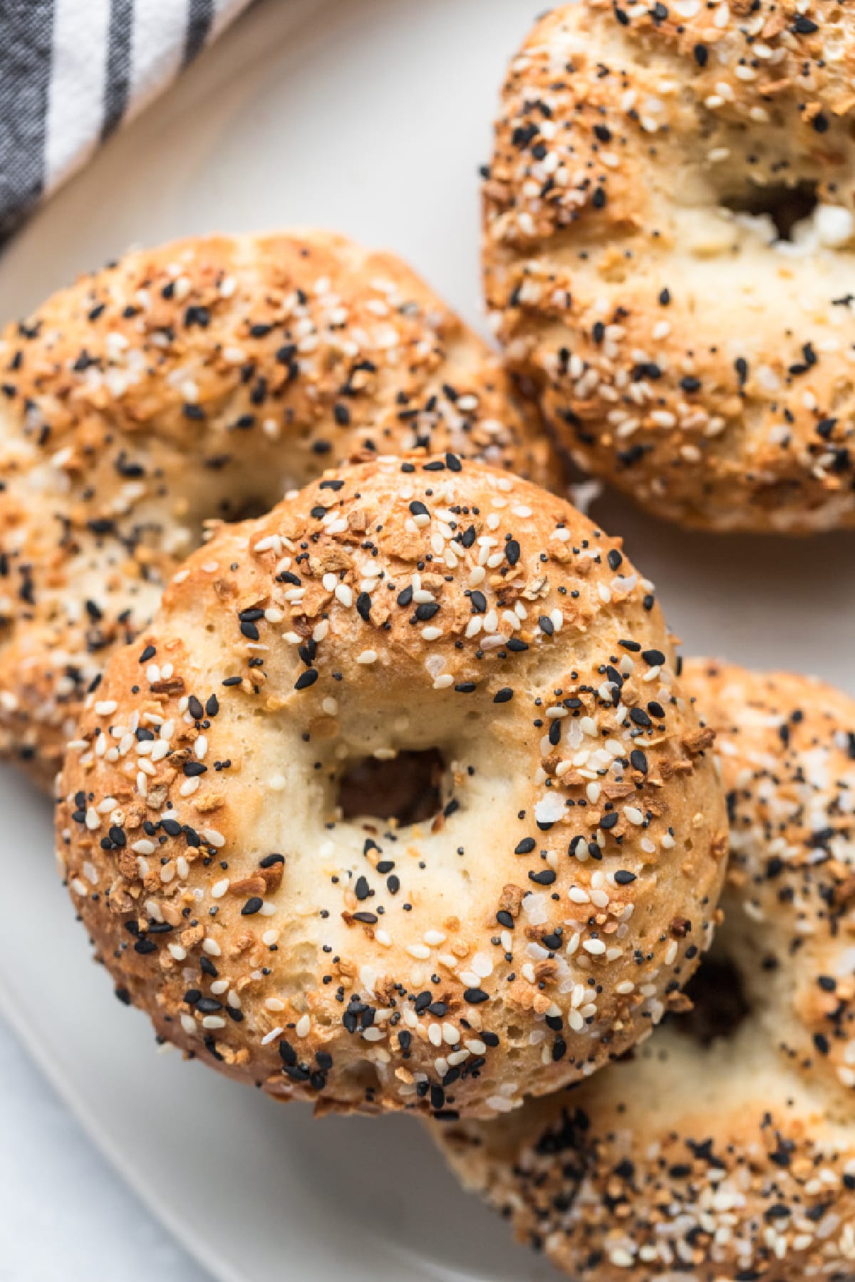 bagels with everything but the bagel seasoning on a white plate.