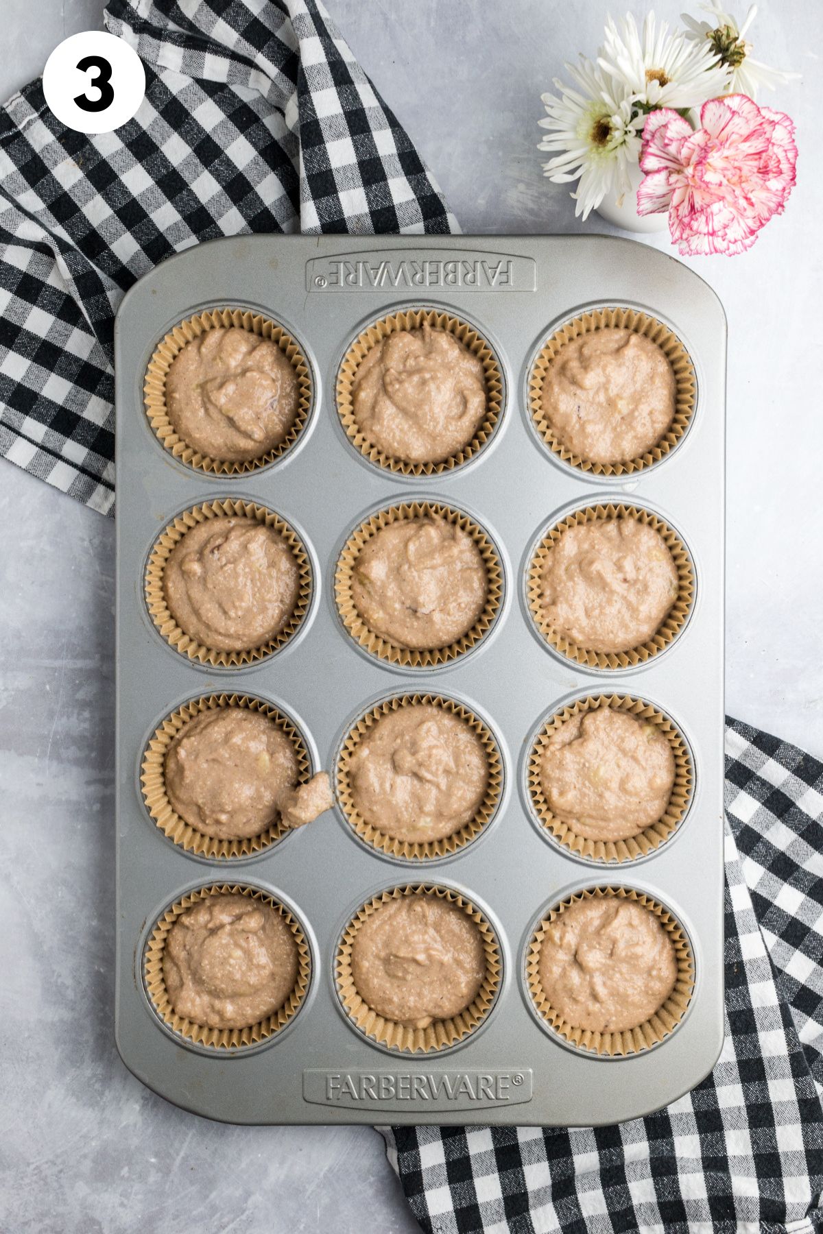 Muffin batter added to a muffin pan.