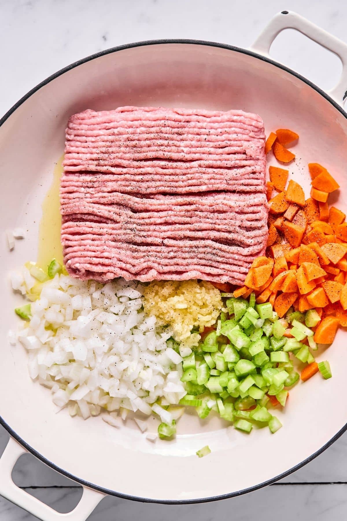 Ground meat and chopped veggies in a pot.