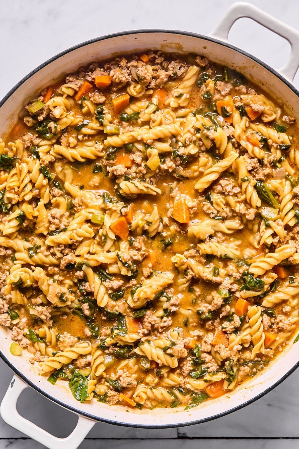 The pasta dish cooking in the pot.