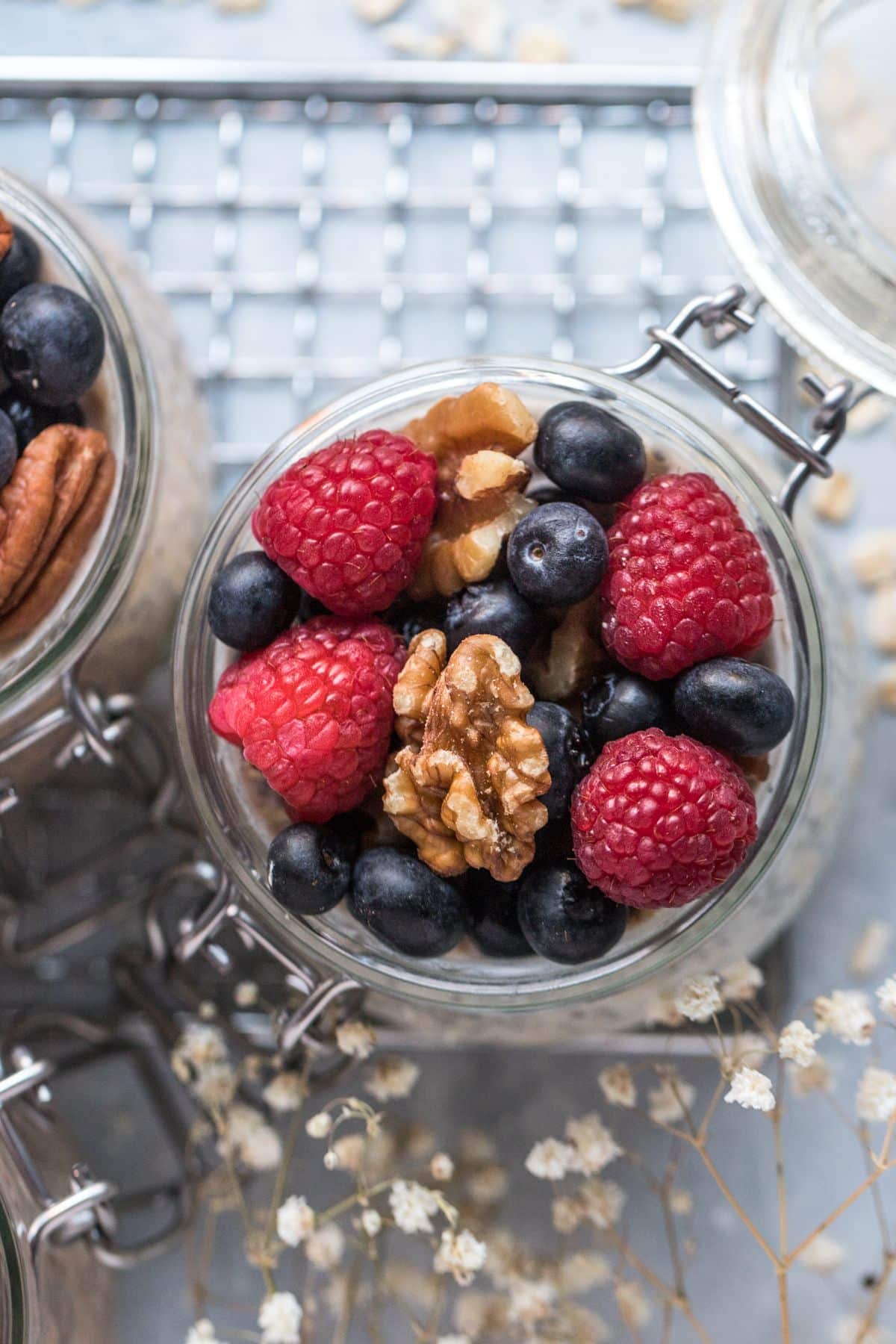 Overnight protein oats in a jar with fresh fruit and nuts on top.