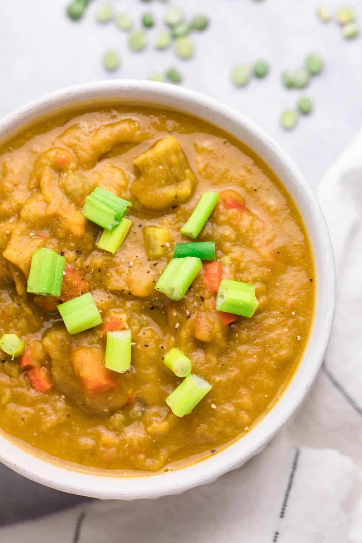 A bowl of vegan split pea soup topped with chopped green onions.