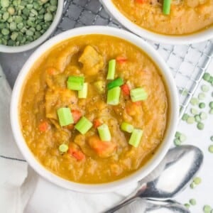 A bowl of vegan split pea soup garnished with green onions.