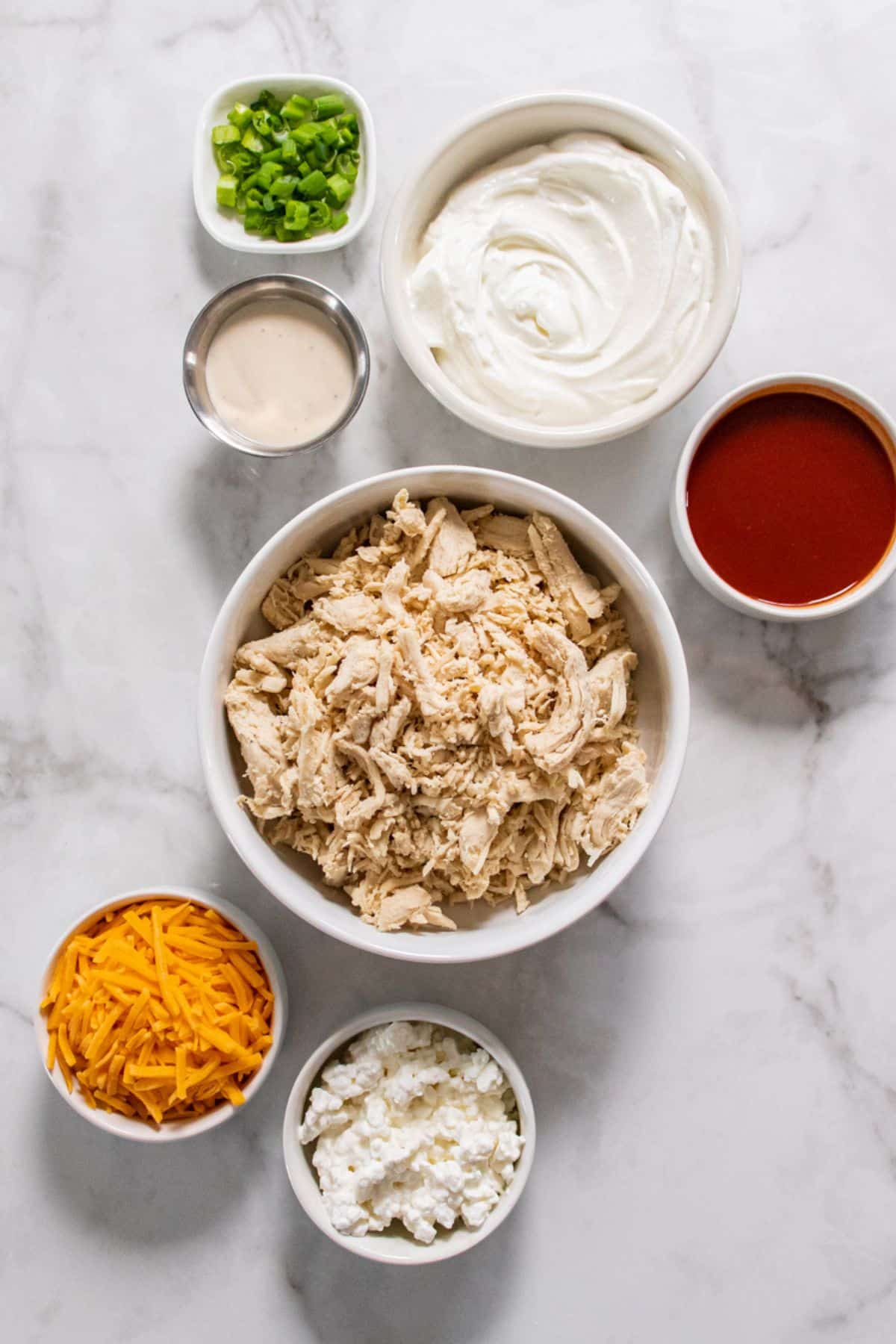 ingredients for buffalo chicken dip with greek yogurt on the table before mixing together.
