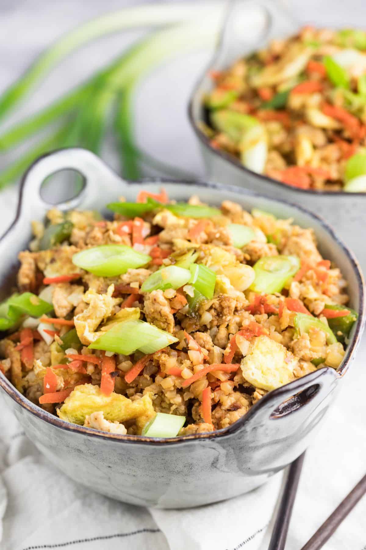 Bowls of healthy fried rice with green onions. 