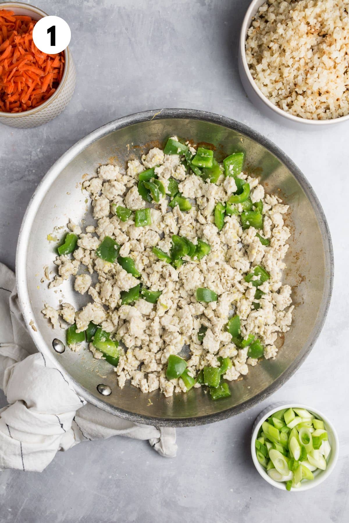 Cooking the ground chicken and green onions in a skillet.