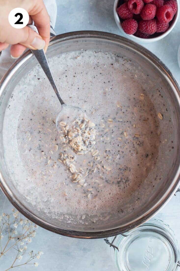 Protein overnight oats mixture in a large pot with a spoon.