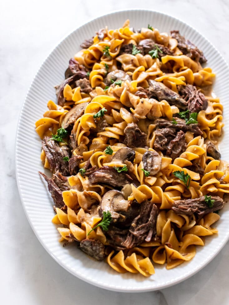 Healthy Beef Stroganoff made gluten free and calorie conscious! This easy dinner recipe is made in an Instant Pot for a healthy meal that can be made in a slow cooker too!