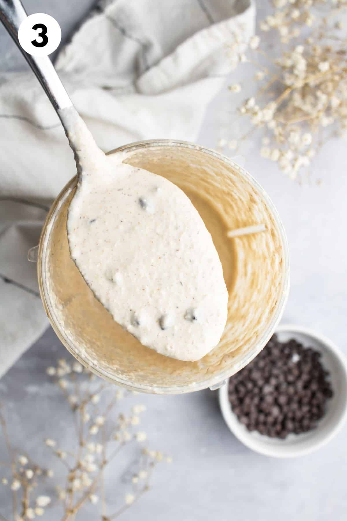 A spoon holding up some of the pancake batter after it's blended.