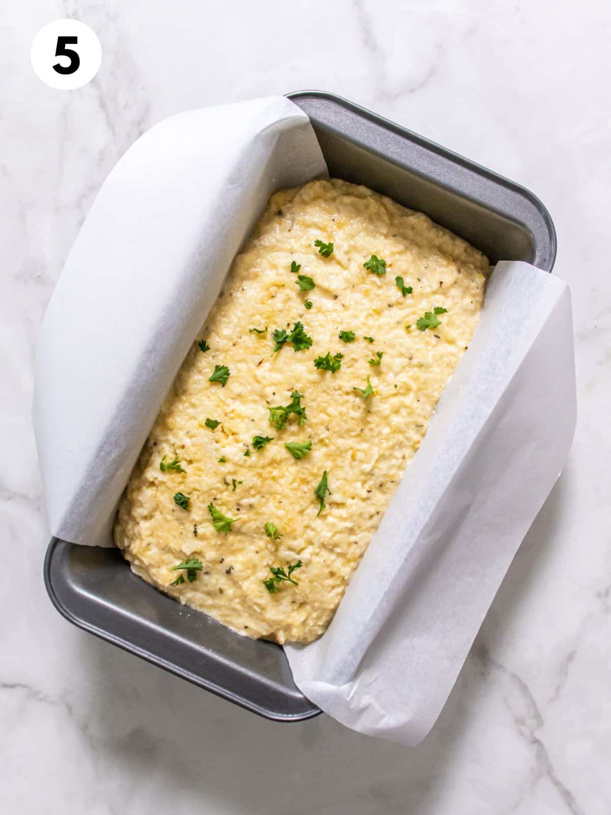 Cauliflower bread in a parchment lined baking pan.