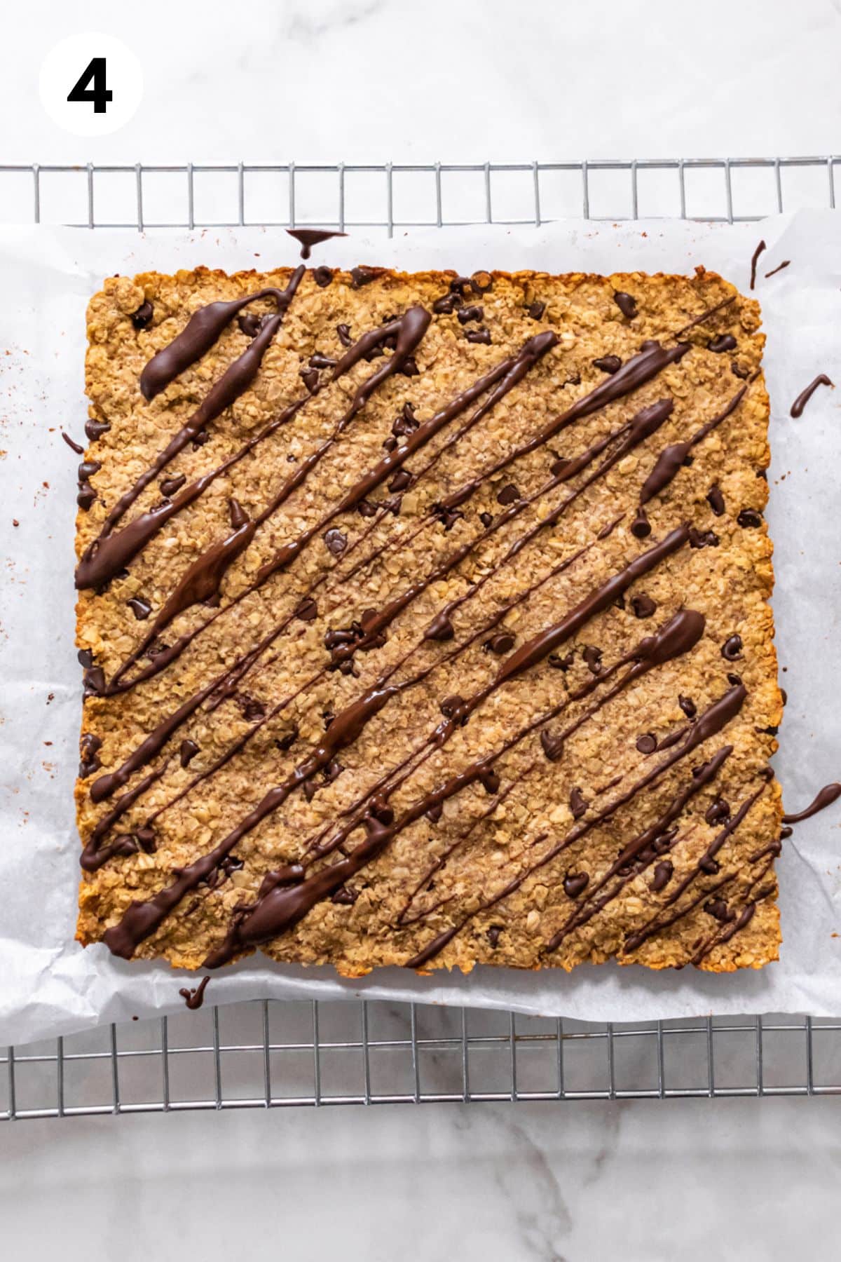 Granola bars are removed from pan and drizzled with chocolate.
