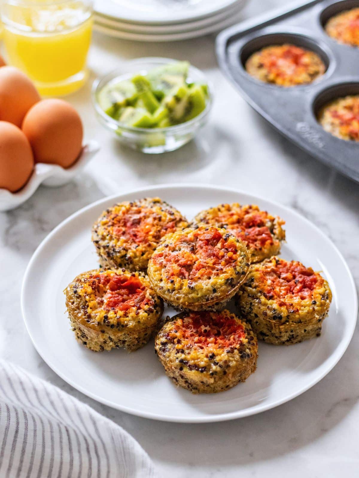 A white plate with quinoa egg bites stacked on top.