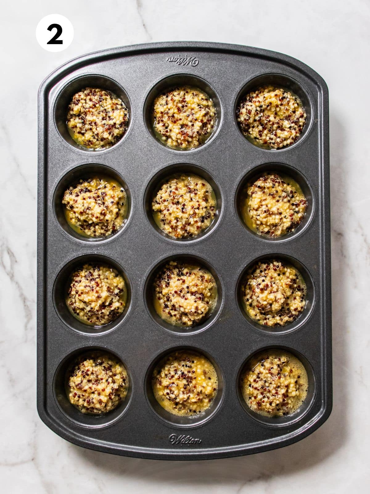 Quinoa and egg mixture is added to a mini muffin pan.